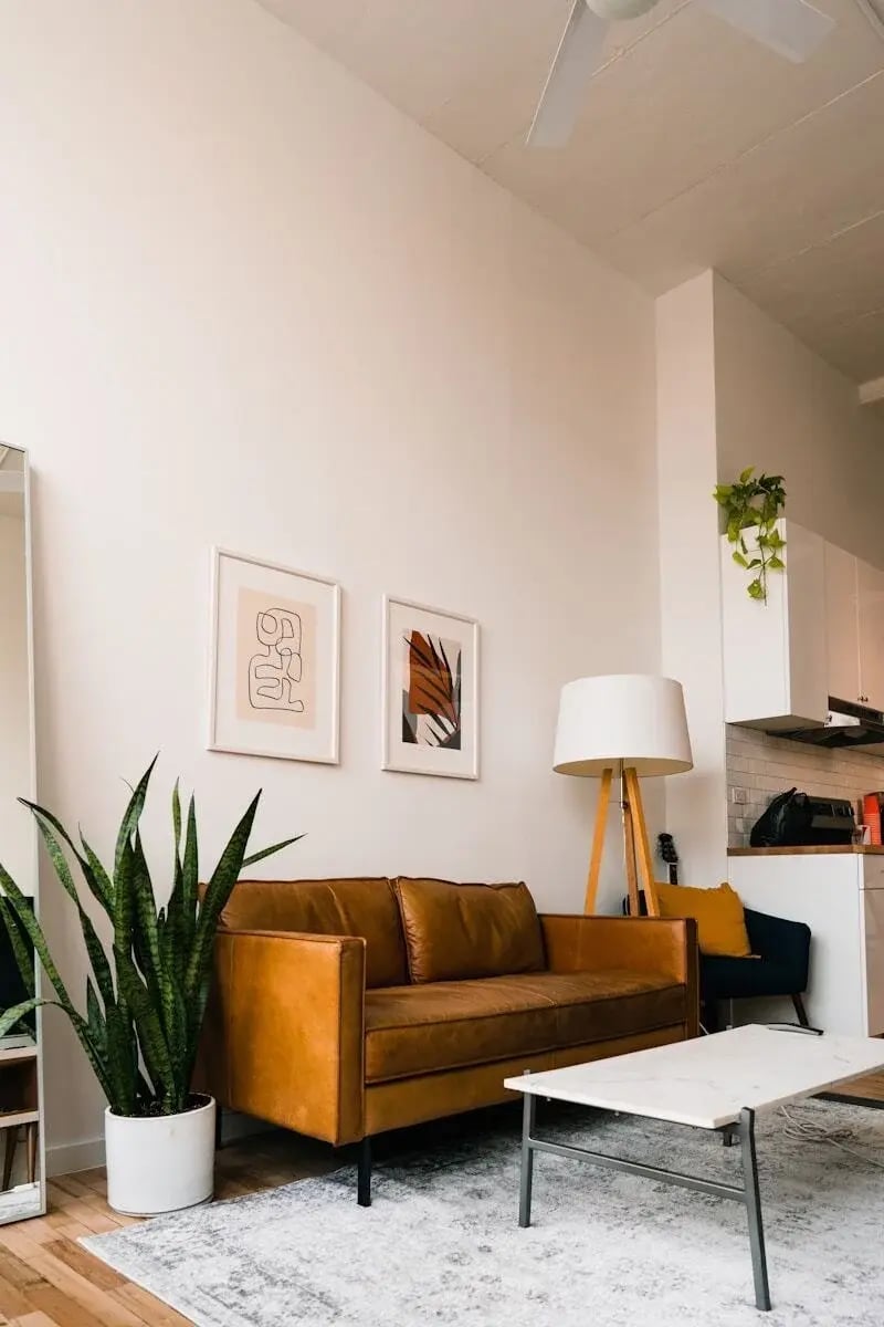 Brown leather sofa and white marble coffee table over a light distressed carpet